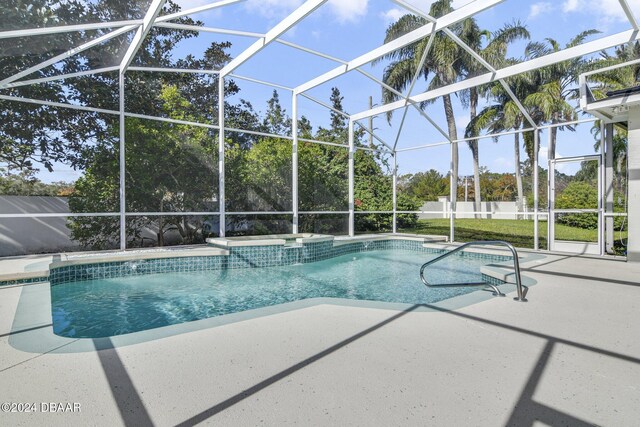 view of pool with glass enclosure and a patio area