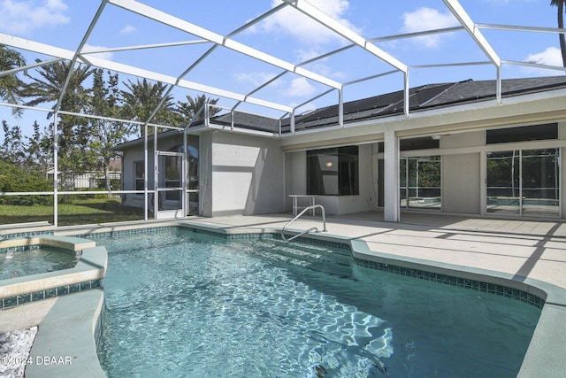 view of swimming pool with an in ground hot tub, glass enclosure, and a patio area