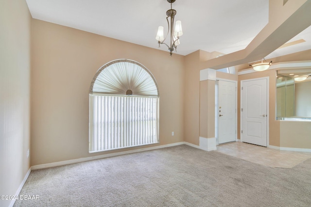 empty room with light carpet and an inviting chandelier