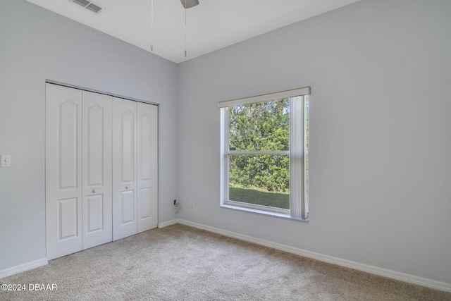 unfurnished bedroom featuring carpet flooring, ceiling fan, and a closet