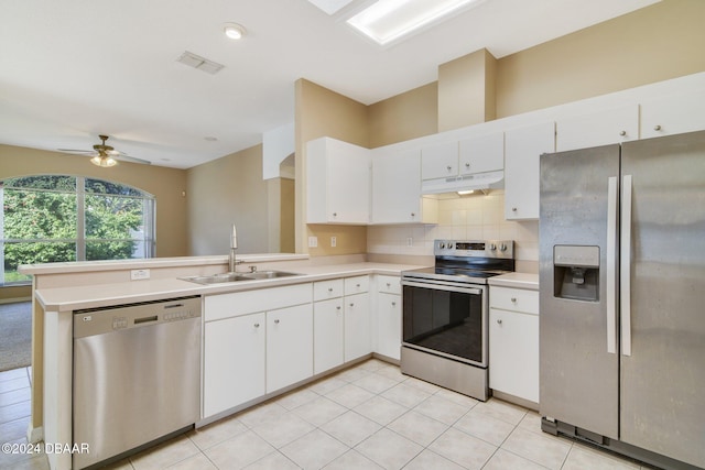 kitchen with kitchen peninsula, stainless steel appliances, ceiling fan, sink, and white cabinets