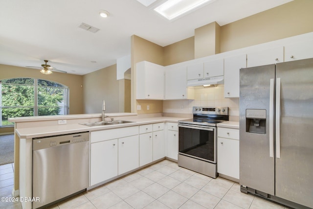 5976 Sawgrass Point Dr, Port Orange, FL 32128 - kitchen featuring stainless steel appliances, under cabinet range hood, a peninsula, light countertops, and white cabinetry