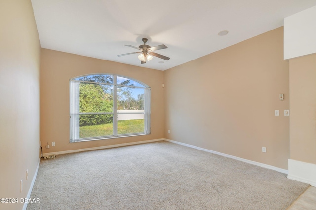 spare room with ceiling fan and light carpet