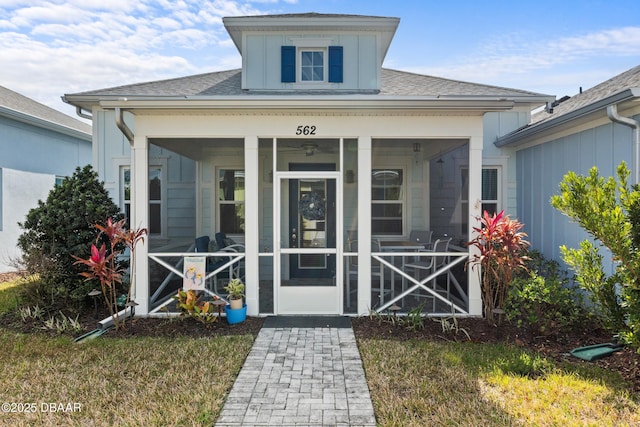 view of exterior entry with a shingled roof