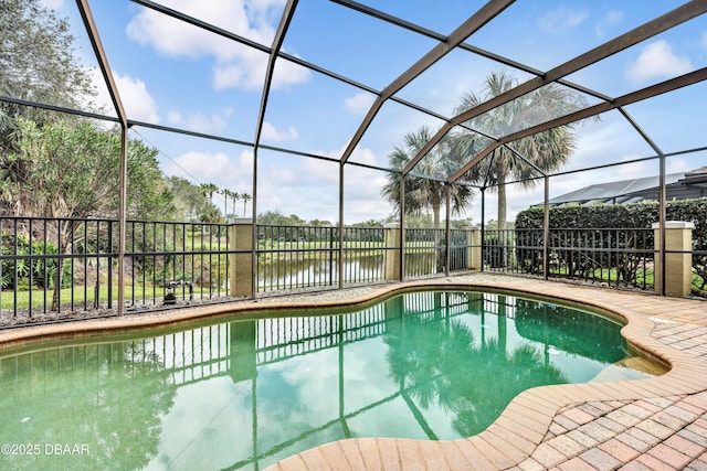 view of swimming pool featuring a lanai, a water view, a patio area, and a fenced in pool