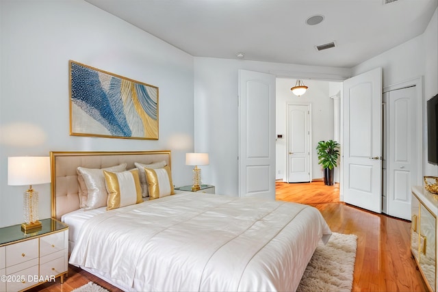 bedroom with visible vents and light wood-style floors