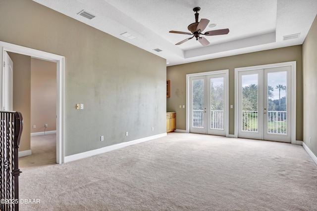 spare room with baseboards, visible vents, a raised ceiling, and french doors