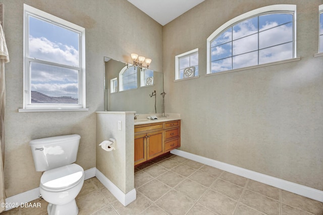 bathroom featuring baseboards, vanity, toilet, and tile patterned floors