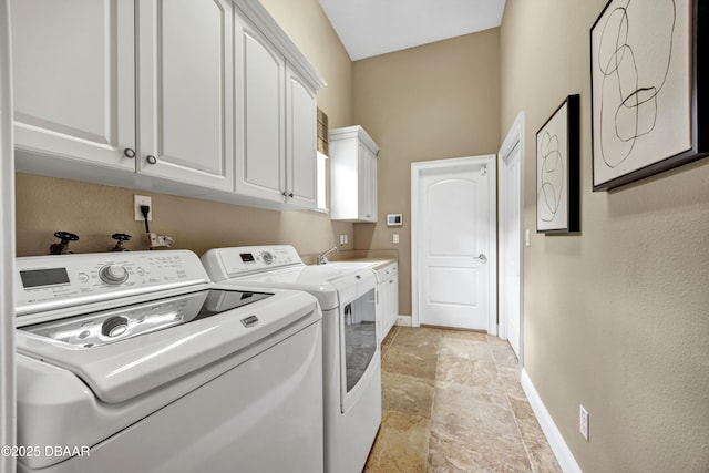 clothes washing area featuring stone finish floor, cabinet space, independent washer and dryer, and baseboards