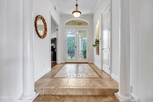 entryway featuring ornamental molding, stone tile flooring, decorative columns, and baseboards