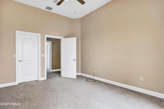 unfurnished bedroom with a ceiling fan, carpet, visible vents, and baseboards