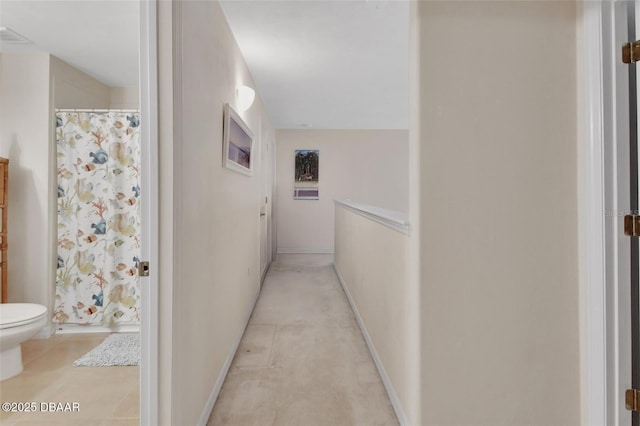 hallway with visible vents and baseboards