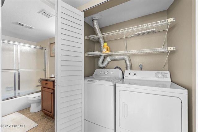 laundry room with independent washer and dryer and light tile patterned floors