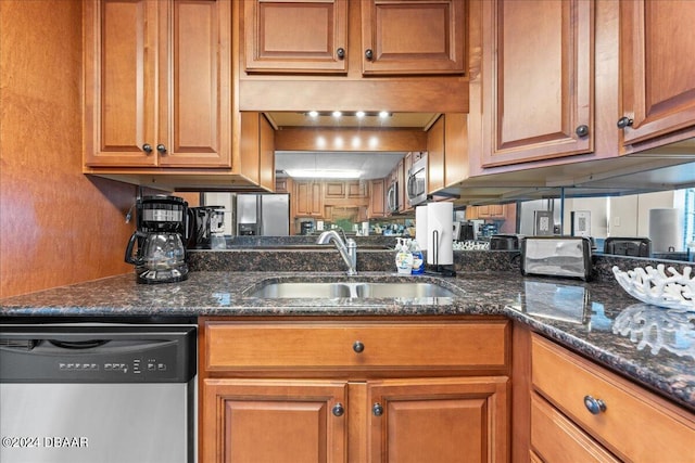 kitchen featuring dark stone countertops, appliances with stainless steel finishes, and sink