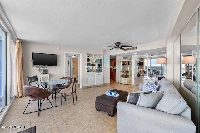 tiled living room featuring ceiling fan and a textured ceiling