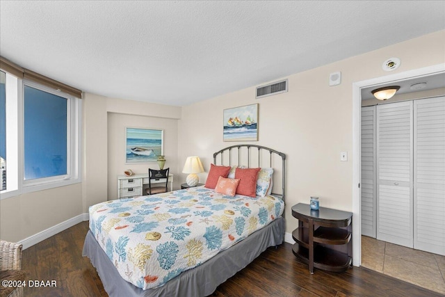 bedroom with dark hardwood / wood-style flooring and a textured ceiling