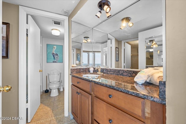 bathroom with tile patterned flooring, vanity, and toilet