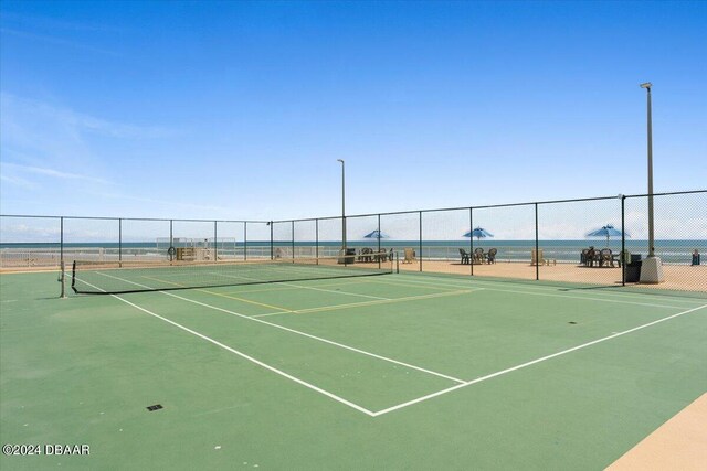 view of tennis court with a water view