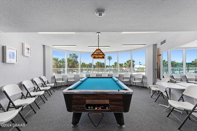 playroom featuring pool table, dark colored carpet, and a textured ceiling