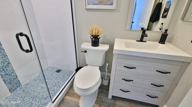 bathroom featuring vanity, hardwood / wood-style flooring, toilet, and a shower with shower door