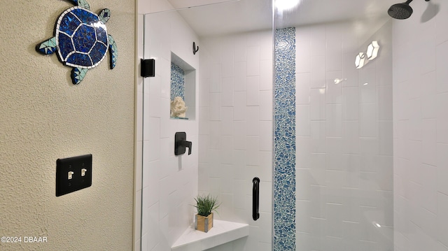 bathroom with a shower with door