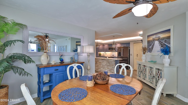 dining space featuring ceiling fan, dark hardwood / wood-style floors, and sink