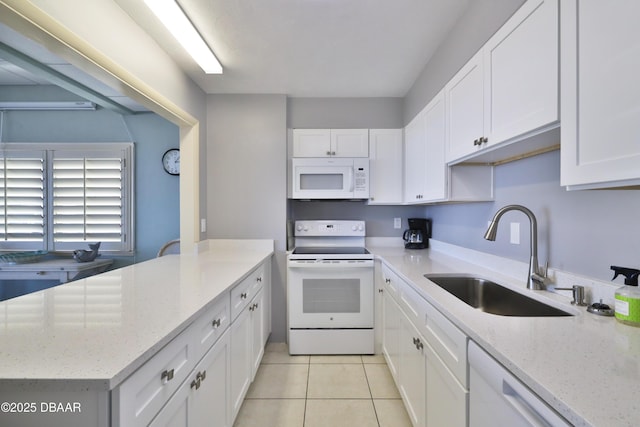 kitchen featuring white appliances, a sink, white cabinetry, and light tile patterned flooring