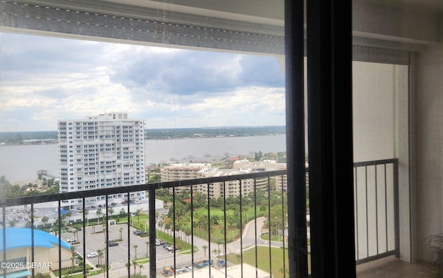 balcony featuring a water view and a city view