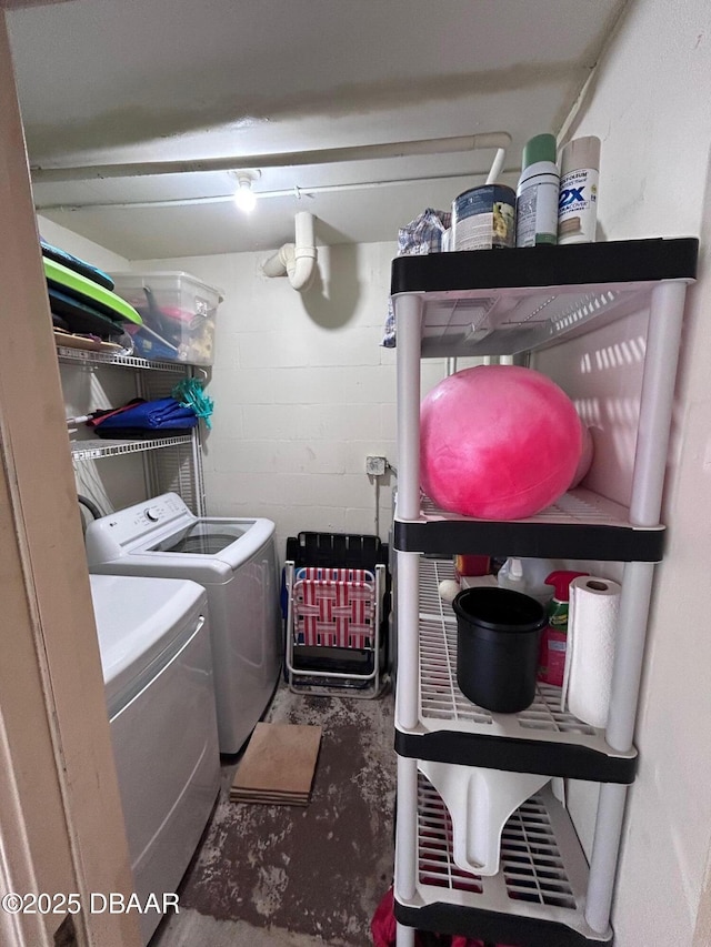 laundry room featuring concrete block wall, laundry area, and washing machine and dryer