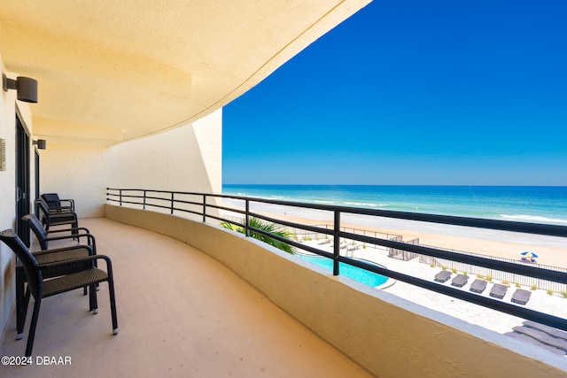 balcony featuring a water view and a beach view