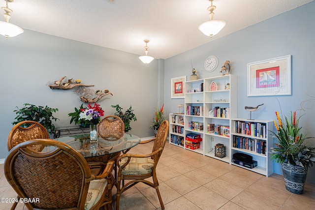 dining space with a textured ceiling, baseboards, and light tile patterned floors