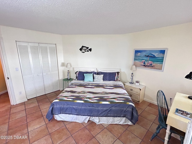 tiled bedroom with a textured ceiling, a closet, and baseboards