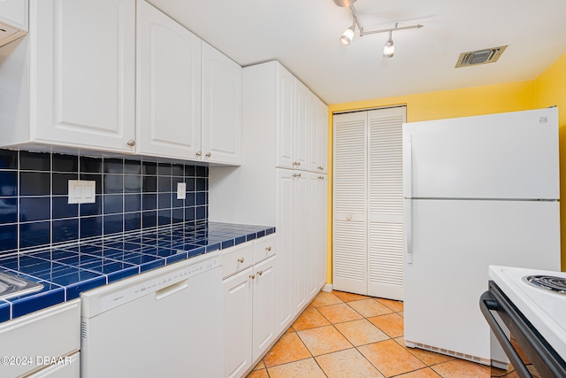 kitchen with tile countertops, white appliances, visible vents, white cabinetry, and backsplash