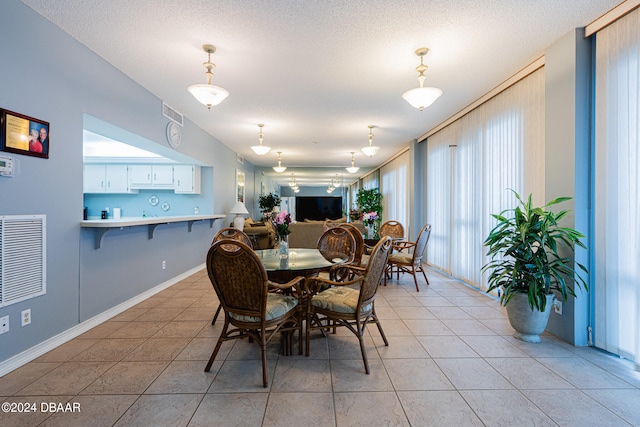 dining space featuring light tile patterned floors and a textured ceiling