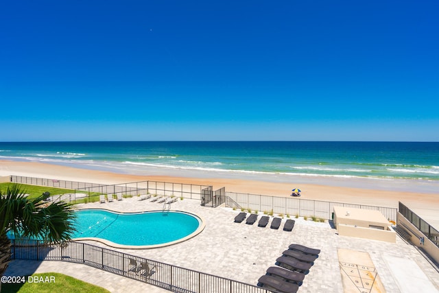 view of swimming pool with a view of the beach, a water view, and a patio area