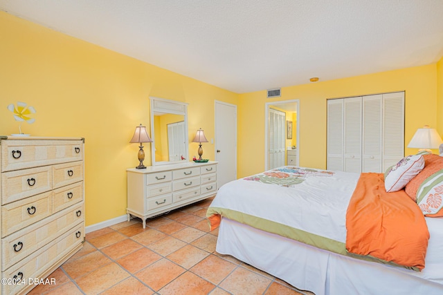 bedroom featuring a closet, light tile patterned flooring, visible vents, and baseboards