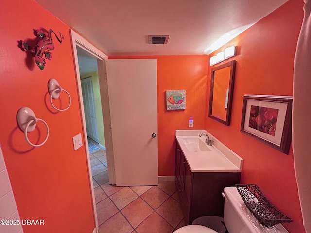 half bath featuring tile patterned flooring, visible vents, vanity, and toilet