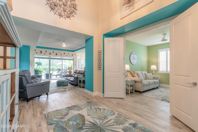 entryway featuring a tray ceiling, ceiling fan, and light hardwood / wood-style flooring