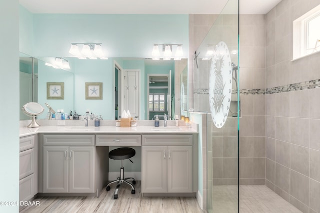 bathroom with vanity, hardwood / wood-style flooring, and a tile shower