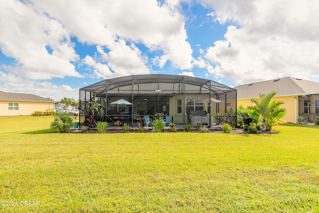 rear view of property with a lanai and a lawn