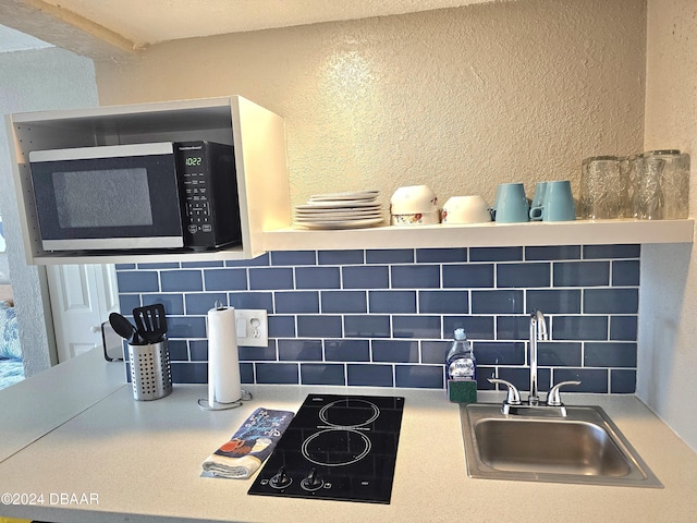 room details with backsplash, sink, and black stovetop