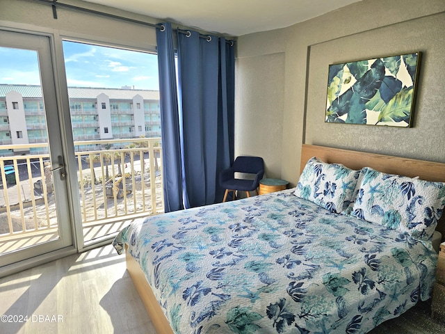 bedroom with wood-type flooring and access to outside