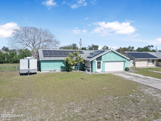 ranch-style home with a front lawn, a garage, and solar panels