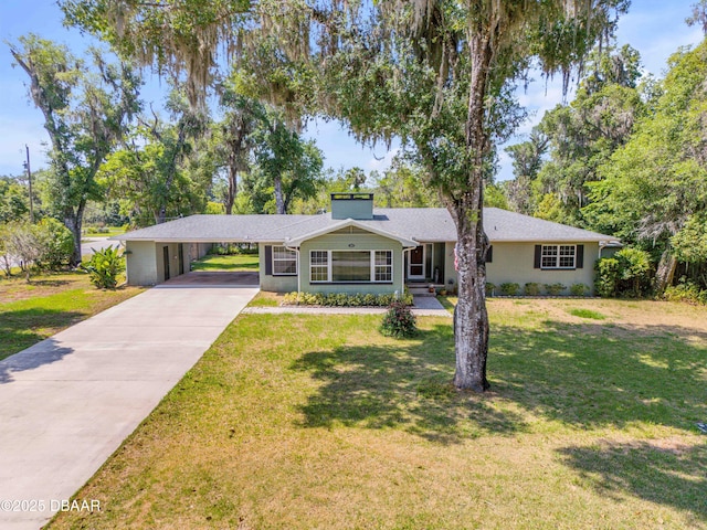 200 W Washington Ave, Deland, FL 32720 - view of front of property with driveway, a front yard, an attached carport, and a chimney