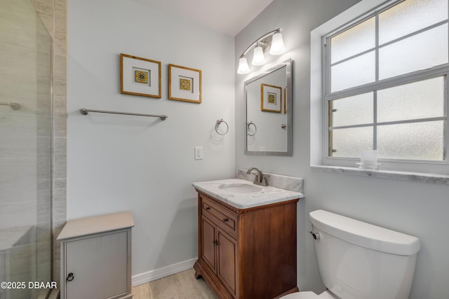 200 W Washington Ave, Deland, FL 32720 - full bath featuring vanity, toilet, wood finished floors, a tile shower, and baseboards