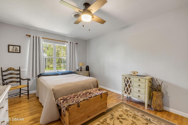 200 W Washington Ave, Deland, FL 32720 - bedroom with light wood finished floors, baseboards, a ceiling fan, and a textured ceiling