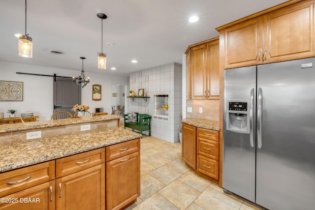 200 W Washington Ave, Deland, FL 32720 - kitchen featuring stainless steel fridge, a barn door, decorative backsplash, light stone countertops, and recessed lighting
