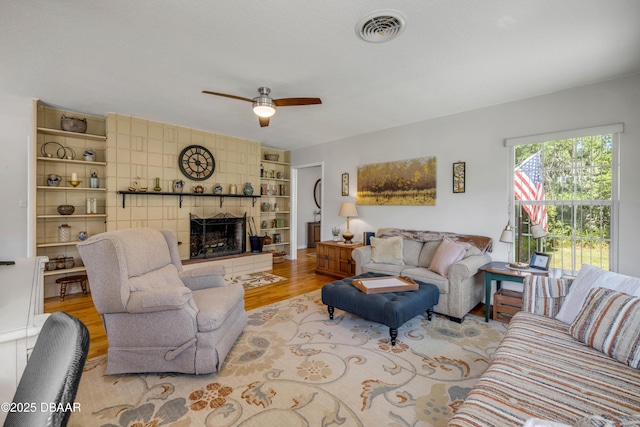 200 W Washington Ave, Deland, FL 32720 - living room with wood finished floors, a ceiling fan, and a tile fireplace