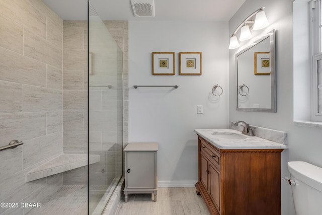 200 W Washington Ave, Deland, FL 32720 - full bath with toilet, vanity, a tile shower, baseboards, and wood finished floors