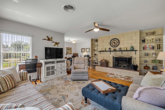 200 W Washington Ave, Deland, FL 32720 - living area featuring a tile fireplace, ceiling fan, and light wood-style floors